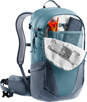 Deuter Futura 27 liter vandringsryggsäck i blått, visad med öppet frontfack som innehåller karta, snacks, penna och första hjälpen-instruktion – organiserad och funktionell design för dagsturer.