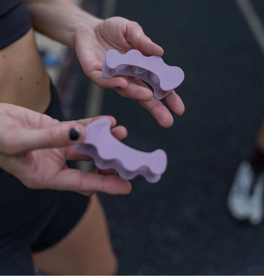 Närbild på en rosa tåseparator för höger fot från Correct Toes Sport, tillverkad i flexibel medicinsk silikon. Produkten visar en anatomisk fotillustration samt texten ”Correct Toes Sport R”.